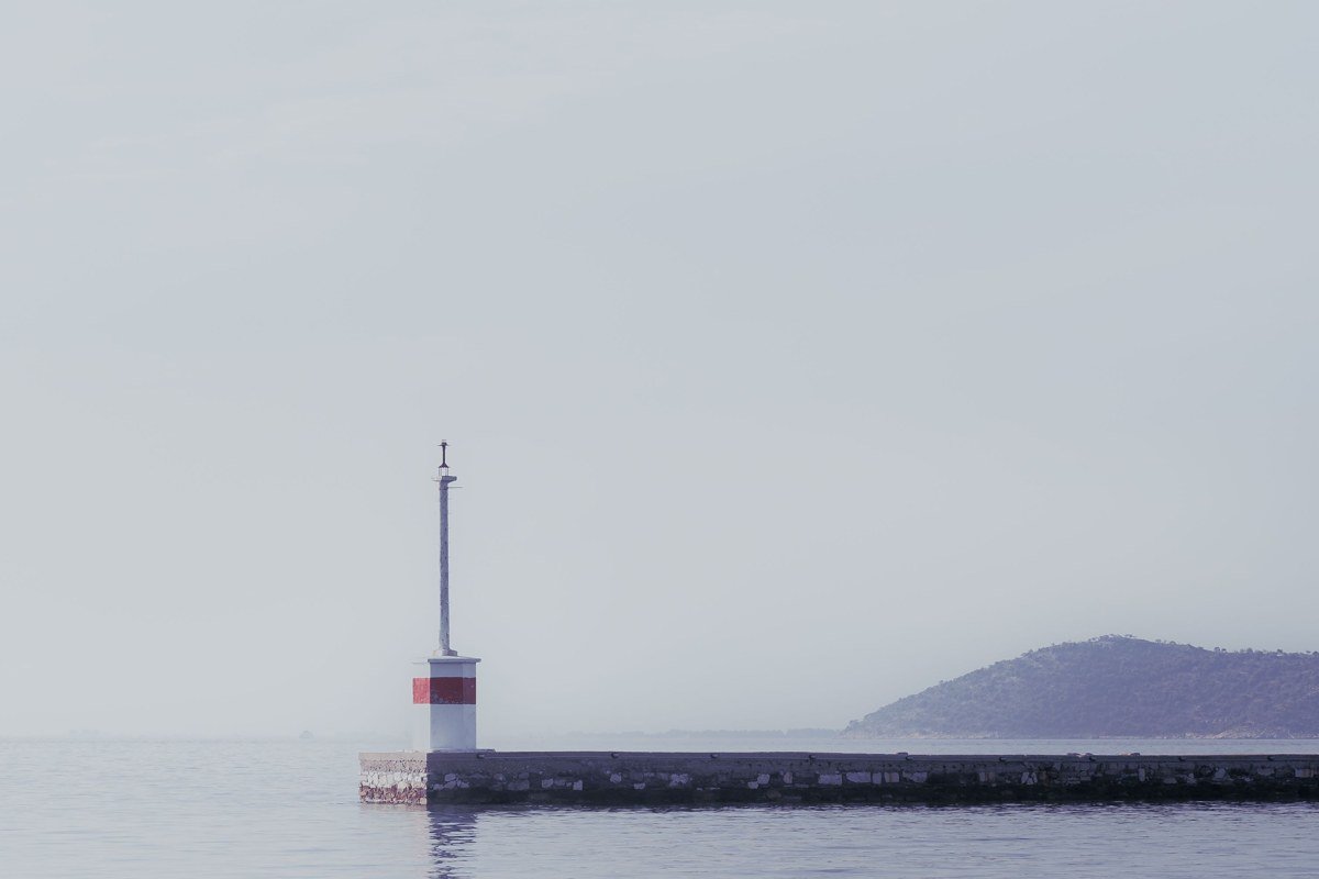 Menominee North Pier Light at 6 a.m., fog reducing the lighthouse to a soft outline against Green Bay