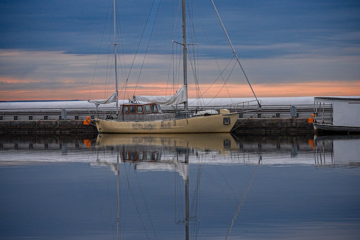 fishing boats at Grand Marais harbor, hulls visible but masts disappearing into fog