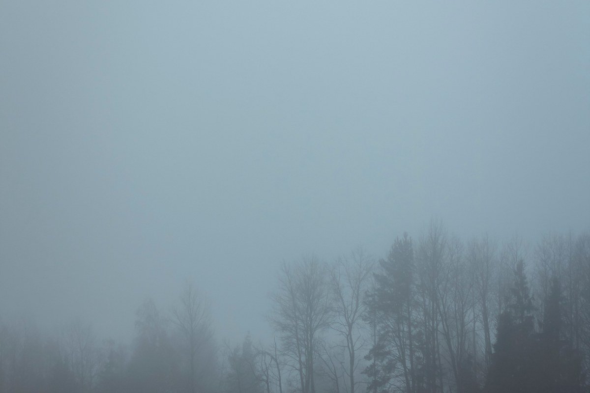 Whitefish Point Light barely visible above a low fog bank, no horizon line distinguishable