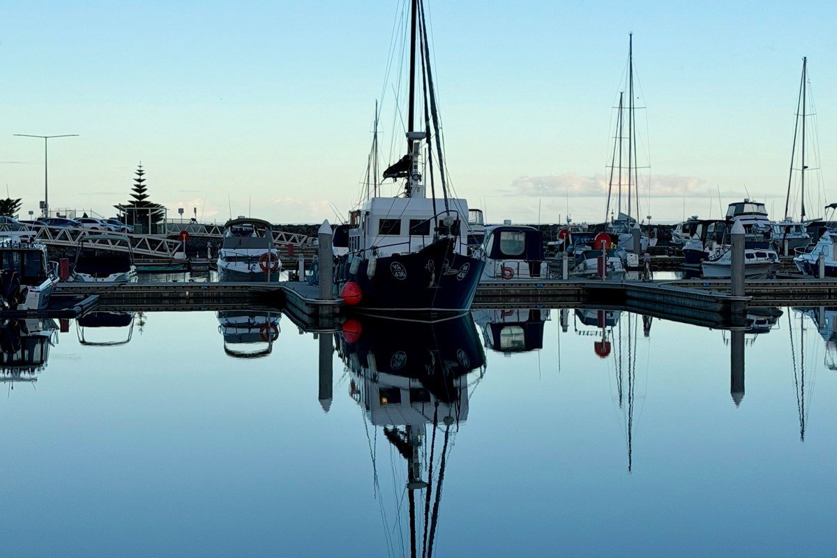 Tenants Harbor public landing at sunrise, lobster boats reflected in still water