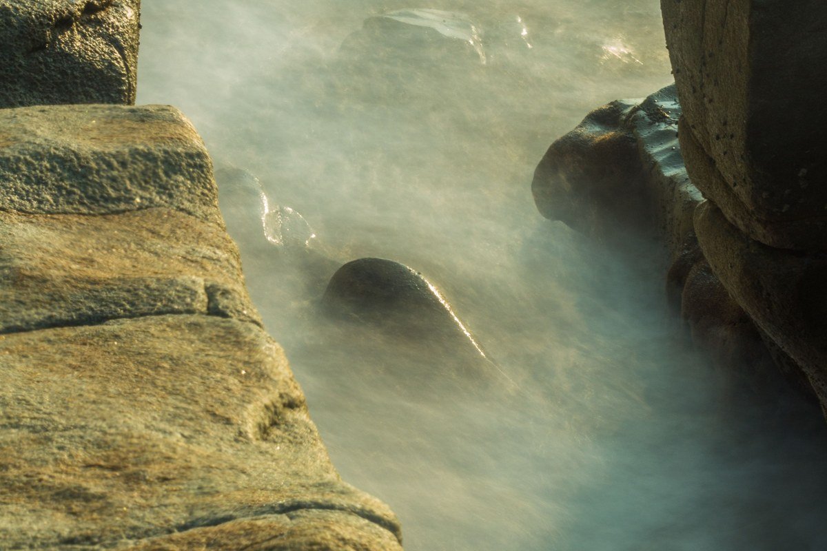 Yachats Oregon rocky tidepool coastline with fog rolling over black rocks