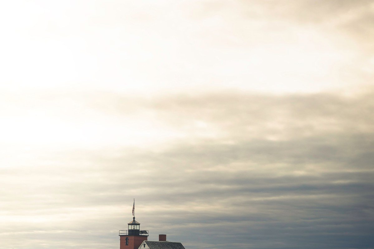 Whitefish Point lighthouse Michigan wrapped in thick lake fog with foghorn tower silhouette