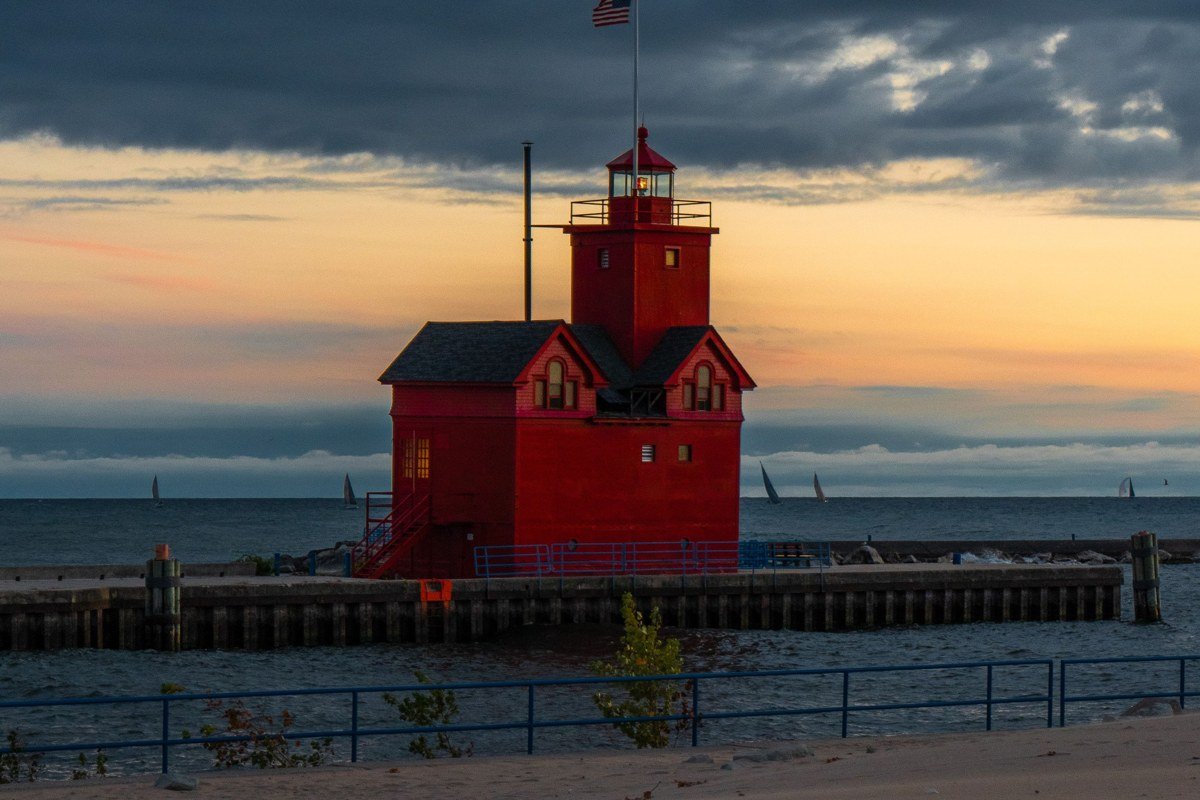 Eagle Harbor Lighthouse Michigan on Keweenaw Peninsula cliffs with fog drifting over red cliffs