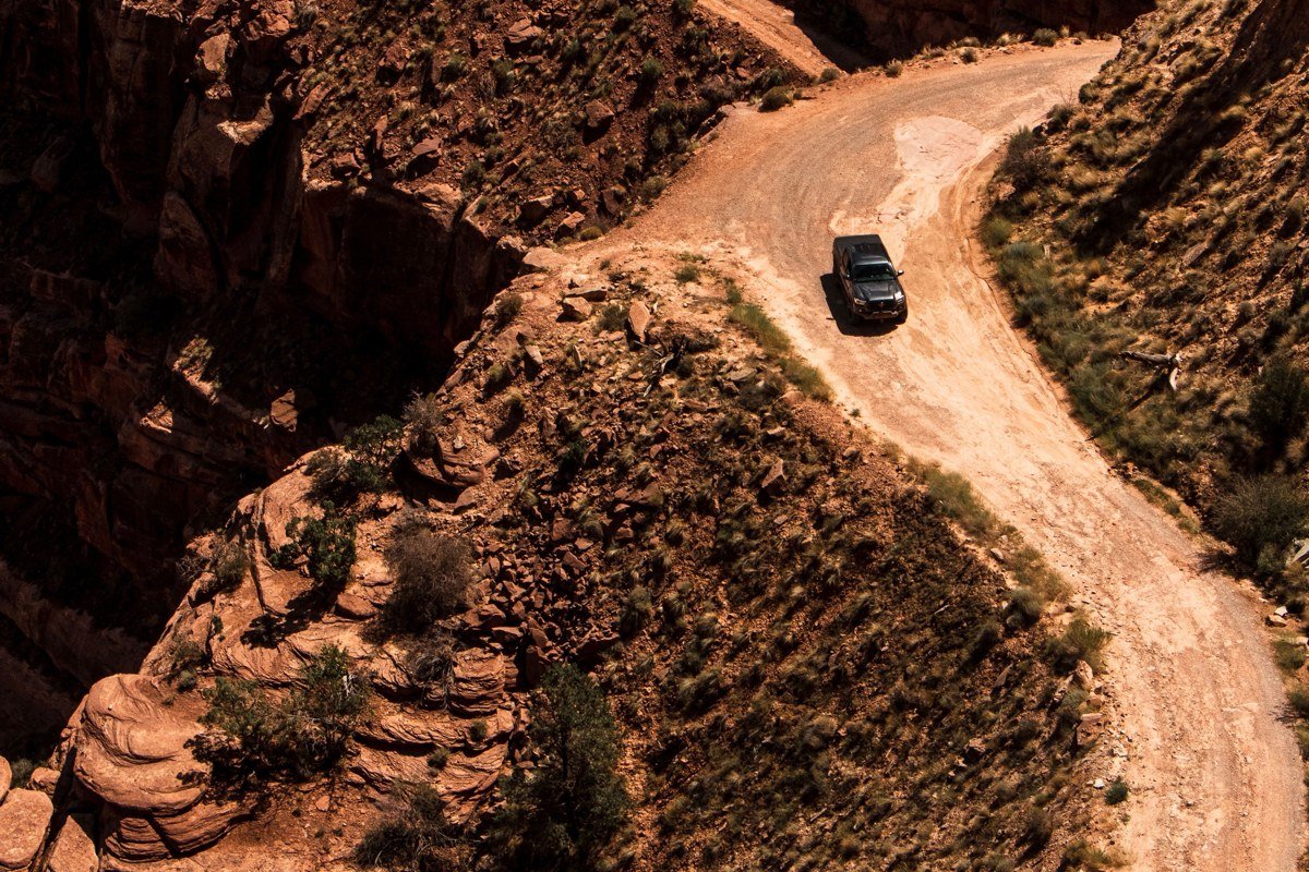wide aerial view of a red rock desert highway winding through southern Utah canyon country at sunset