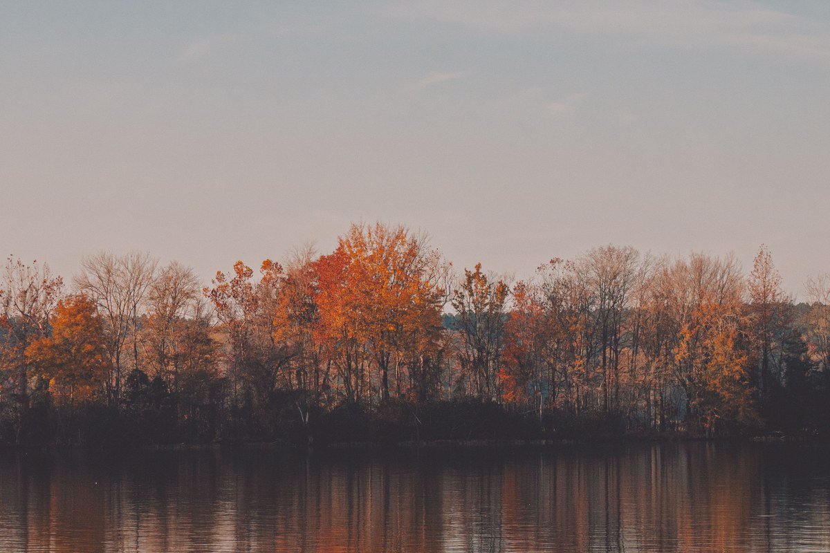 Lake Bomoseen Vermont sunset with fall foliage reflected on calm water