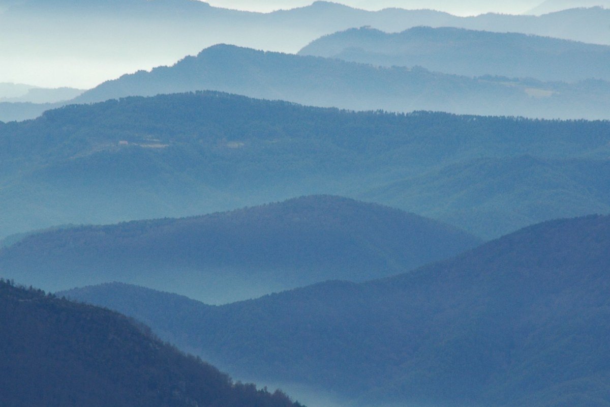 wide misty sunrise view over layered Smoky Mountains ridgelines with fog filling the valleys