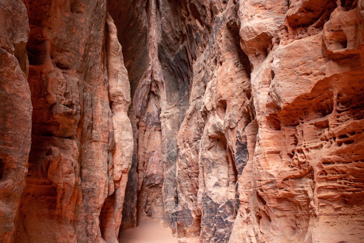 short slot canyon rappel at Keyhole Canyon Zion with narrow orange walls and cool shade
