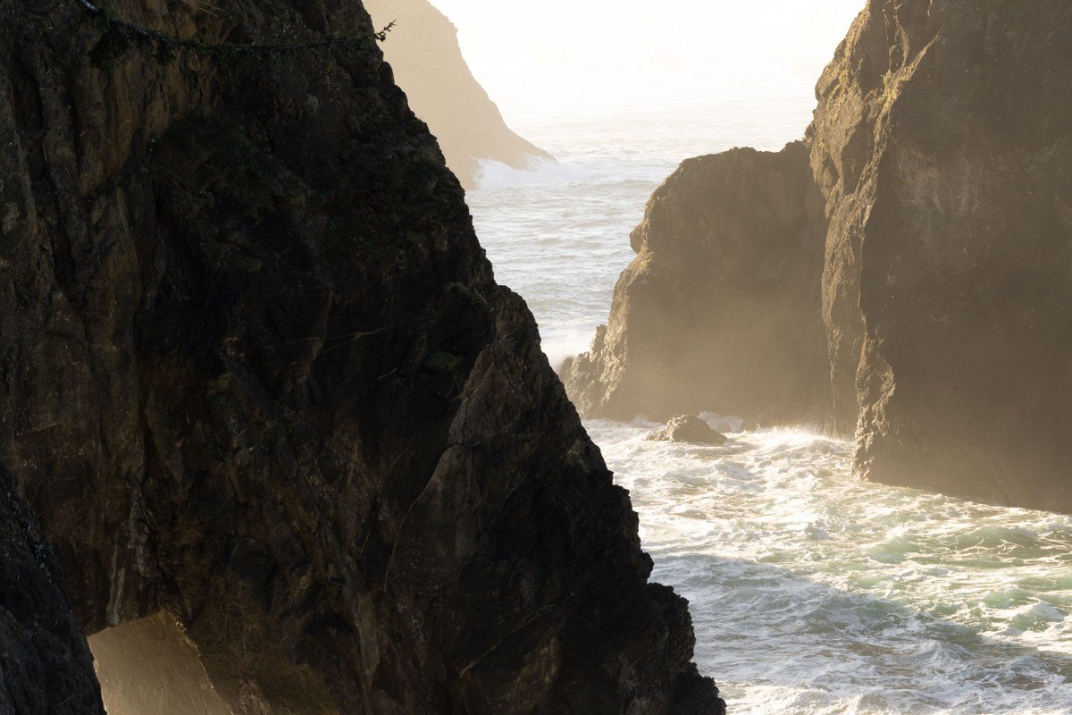 Cape Meares Lighthouse partially obscured by fog on a cliff edge, Oregon