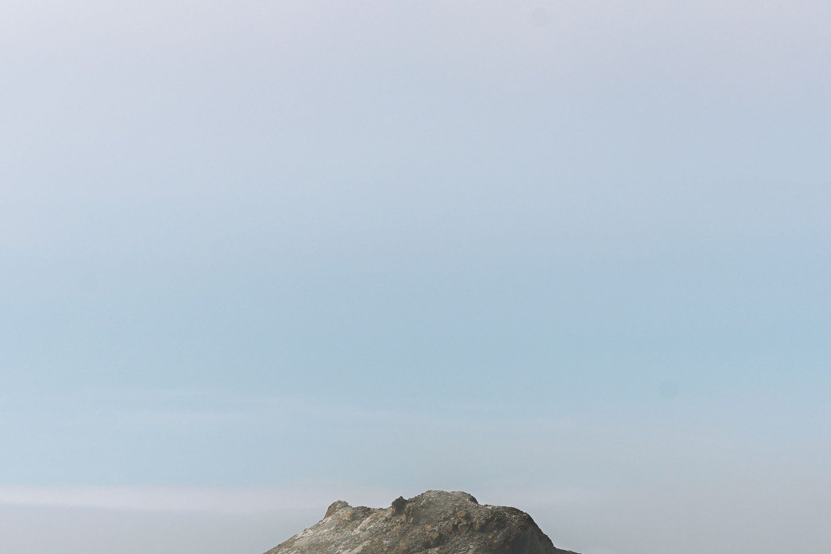 Face Rock and surrounding sea stacks at Bandon Beach wrapped in evening fog, Oregon
