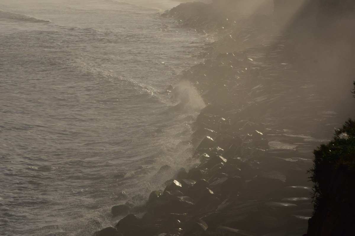wide misty granite coastline of Maine with pine-topped islands fading into fog at dawn