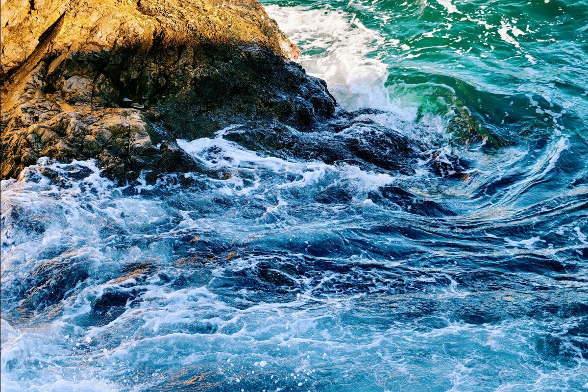McWay Falls dropping onto a sheltered beach cove, viewed from a cliffside overlook, California