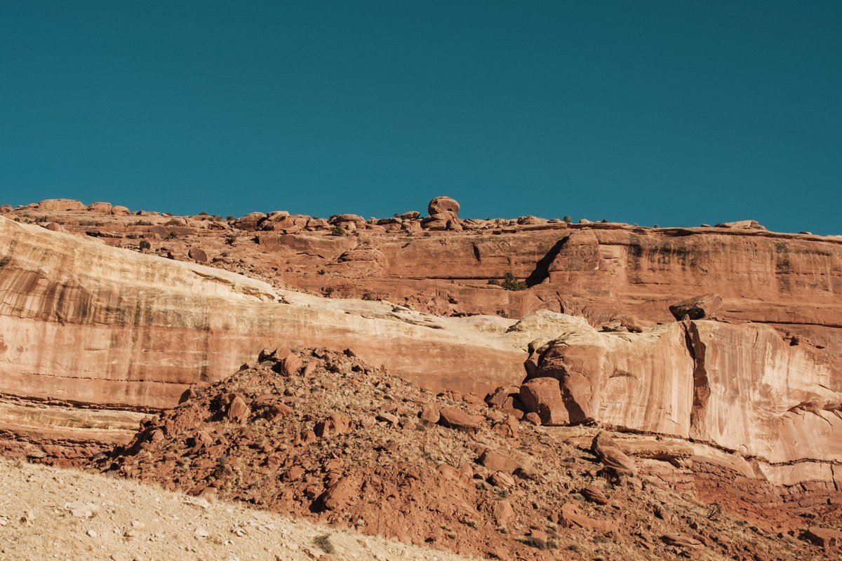 wide clear view of Canyonlands Island in the Sky mesa with layered red rock canyons and distant snow capped La Sal Mountains