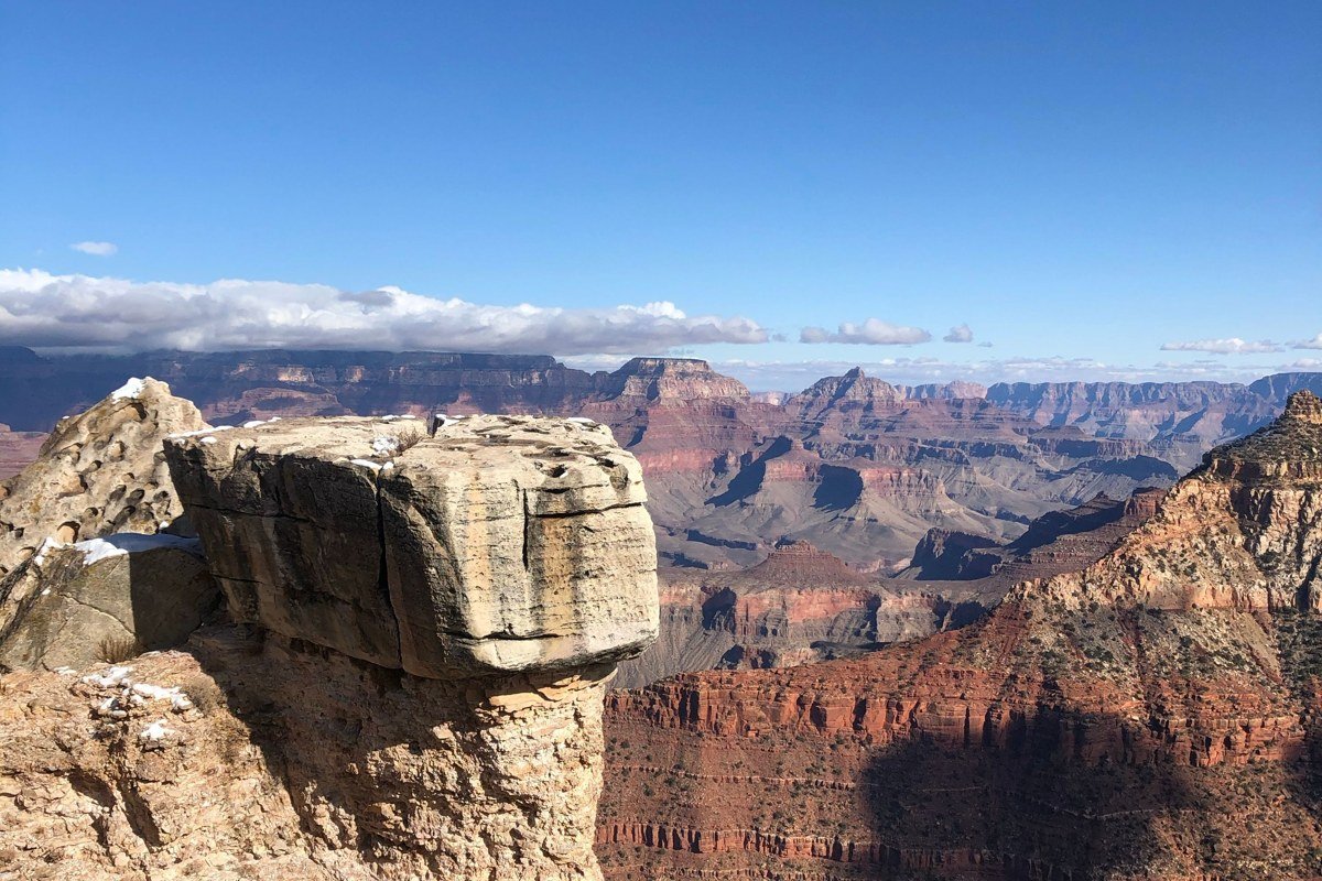 Grand View Point Canyonlands overlook with Colorado River canyon stretching to the horizon under a cloudless blue sky
