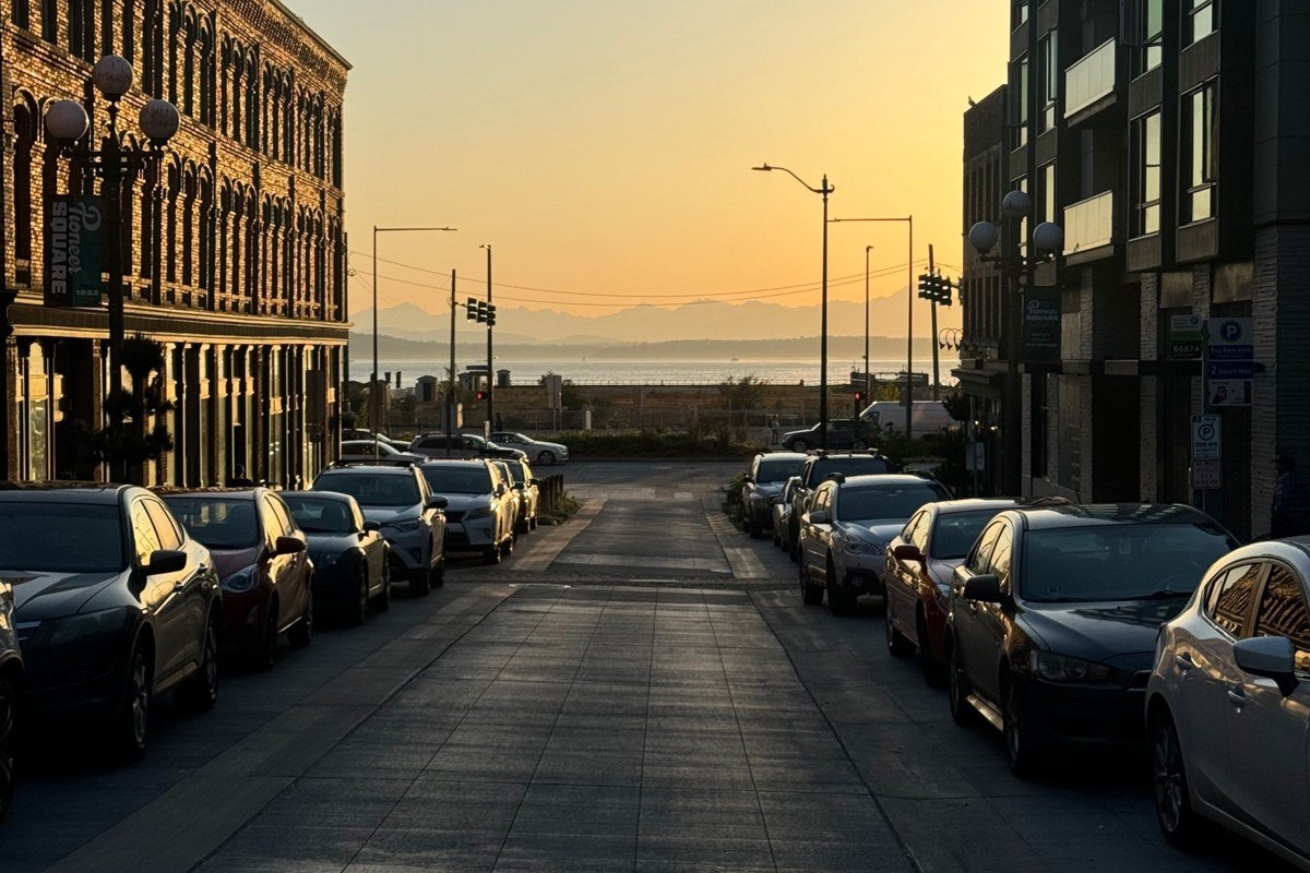 Kanab's Center Street at dusk, shot from the middle of the empty sidewalk looking west toward the red cliffs just past downtown as the streetlights come on