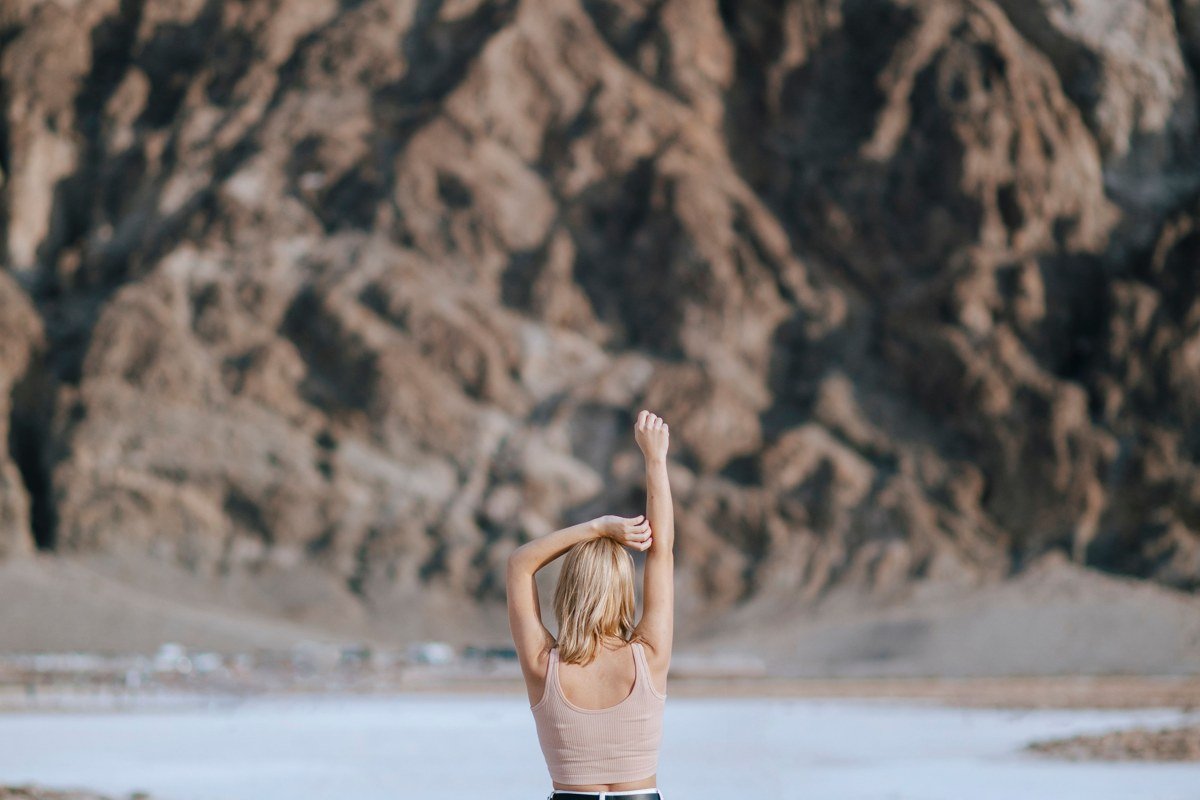 Badwater Basin salt flats in Death Valley California with hexagonal salt crust patterns and mountains behind