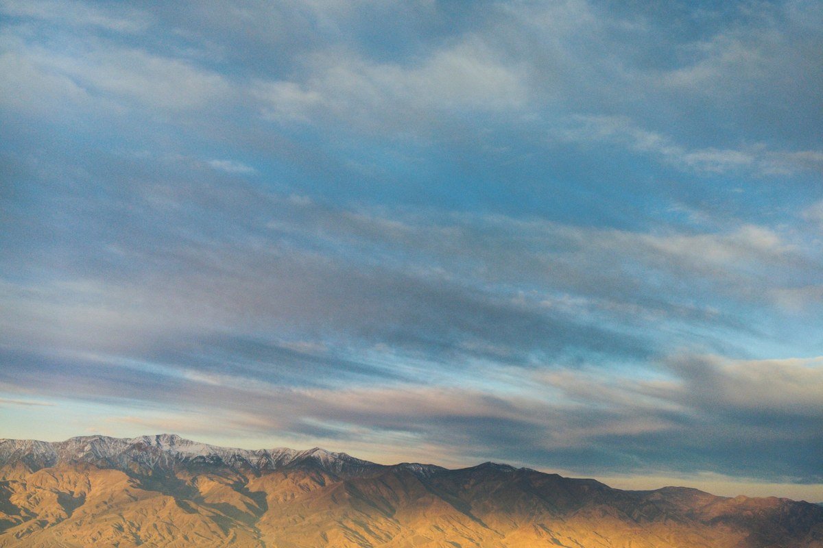 Zabriskie Point badlands at sunrise with golden eroded hills and Death Valley in the background
