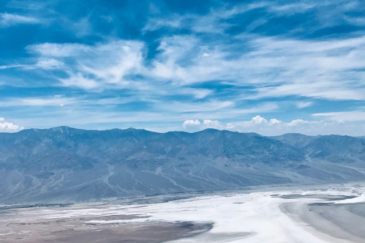 Dante's View overlook showing Badwater Basin salt flats far below and snow-capped Panamint Mountains