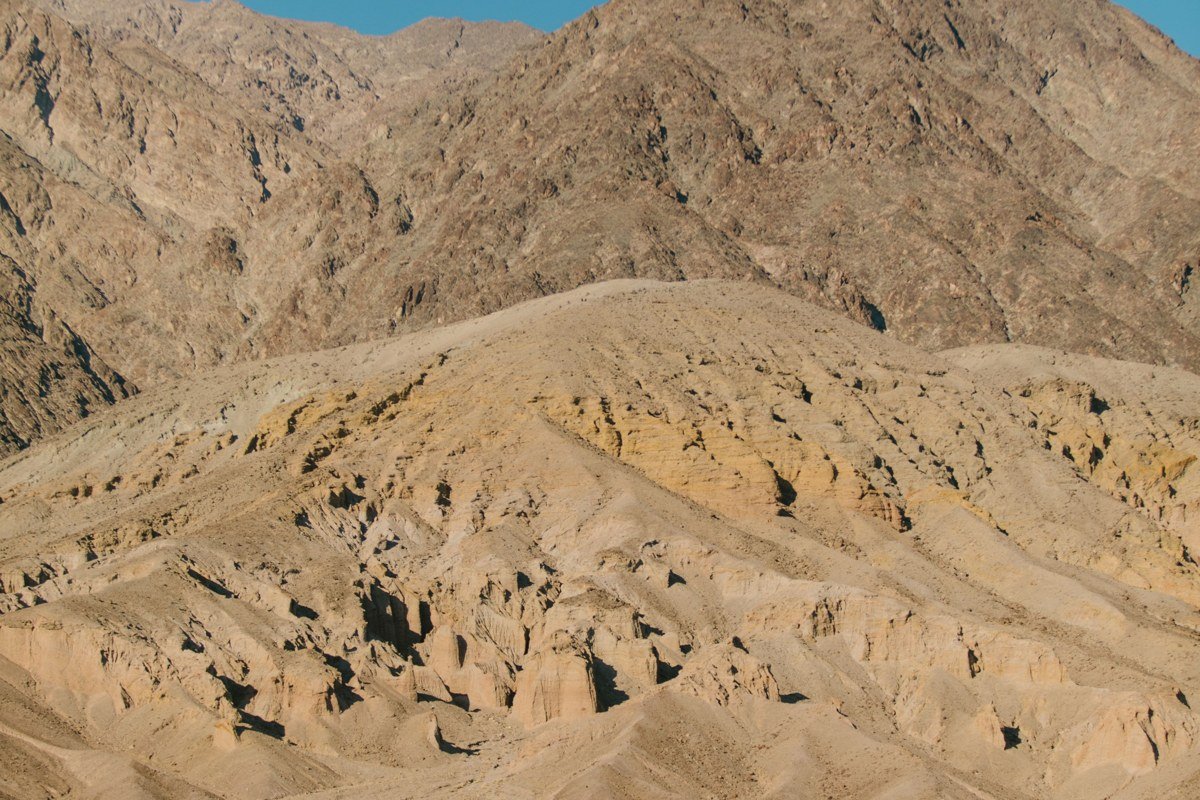 Artists Palette hillsides in Death Valley with green, pink, and purple mineral streaks in afternoon light