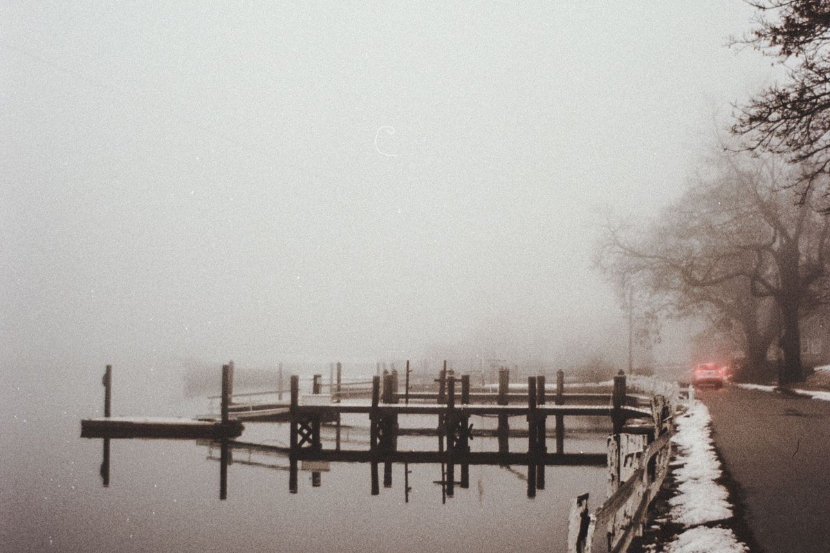 Skaneateles Lake village dock with fog rolling over clear blue water at sunrise