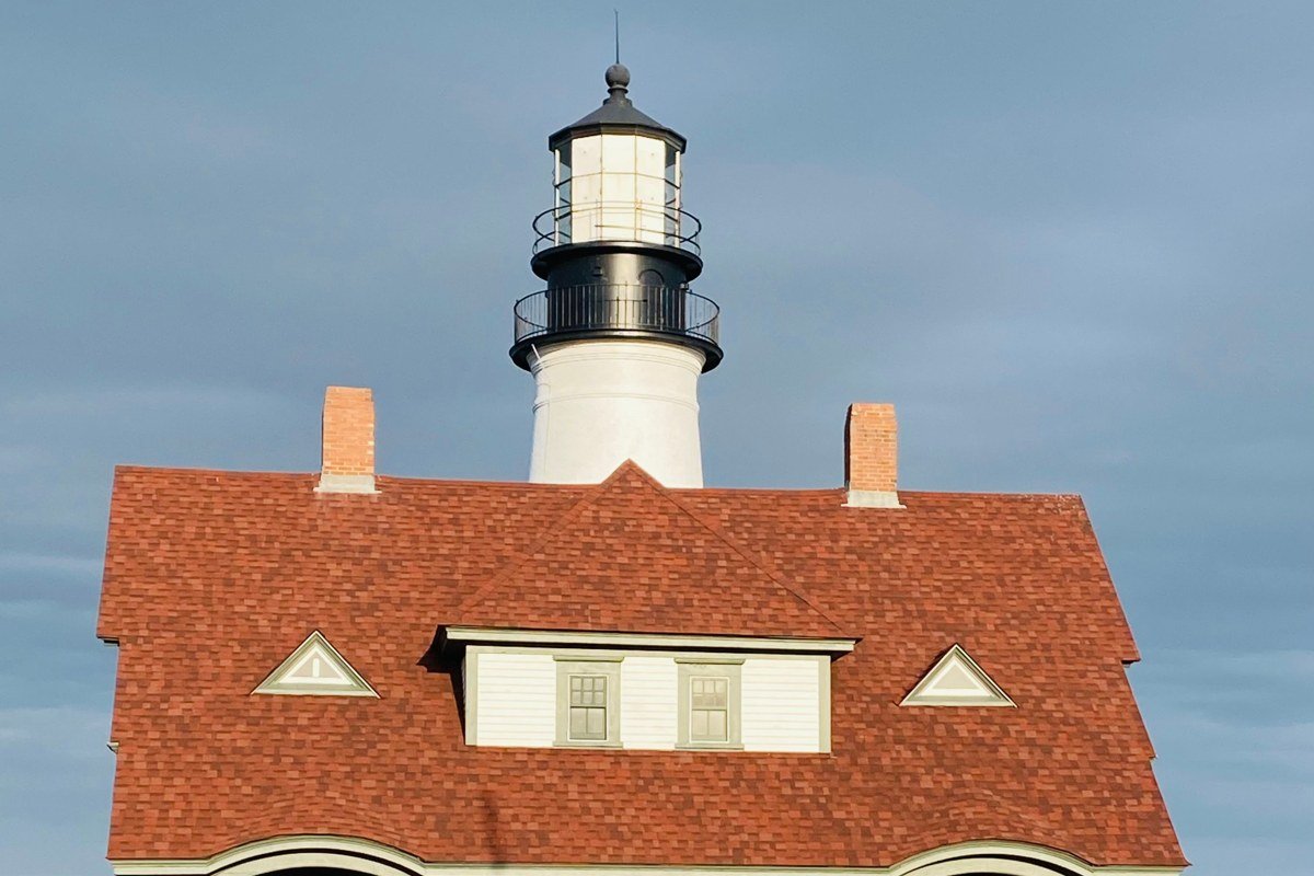 Pemaquid Point Light Maine lighthouse on striated rocks with fog drifting over the sea