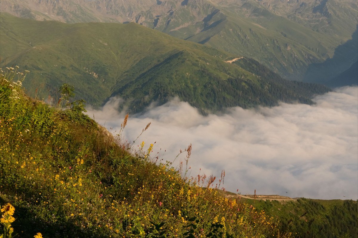 a mountain ridge line clear overhead while the valley below sits buried in cloud