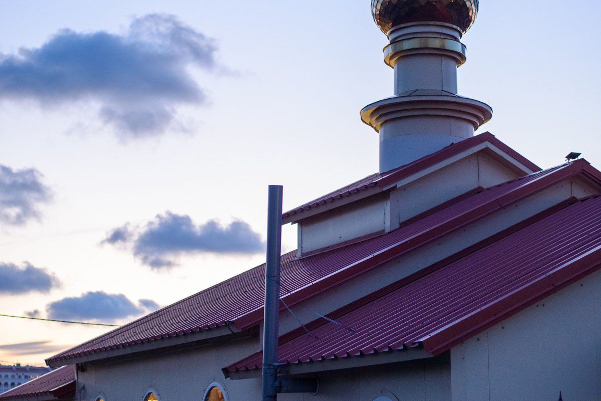 Chapel of the Holy Cross lit up at sunrise, built directly into the red rock