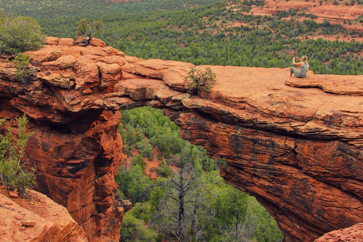 wide panoramic view of Sedona Arizona red rock formations at sunset with Oak Creek Canyon in distance