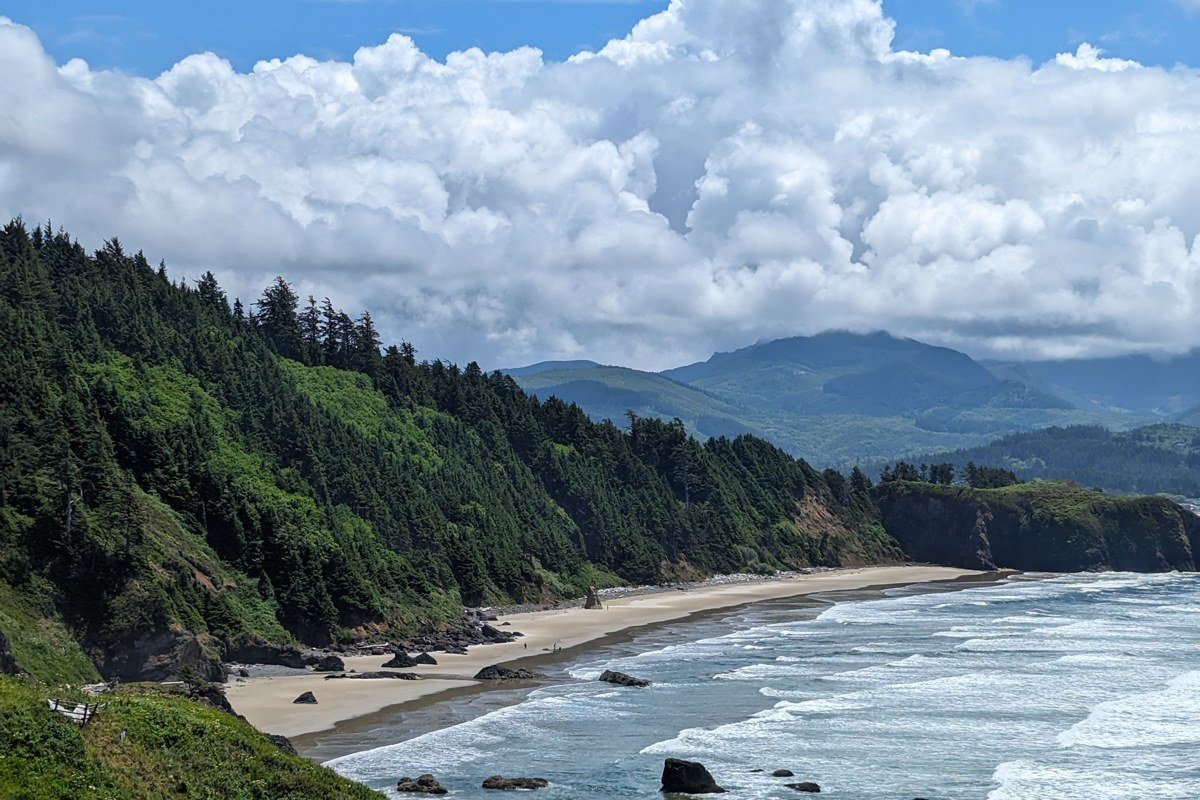 Hug Point sea cave and waterfall on beach at low tide, Oregon coast cliffs