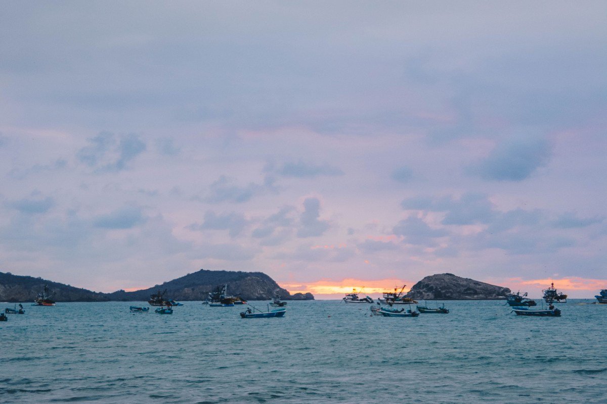 Cape Kiwanda sandstone cliff and dory fishing boats on beach at Pacific City Oregon sunset