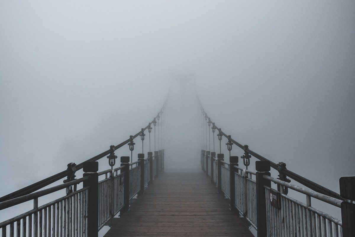 Mystery Bay Washington state park dock disappearing into fog over calm water