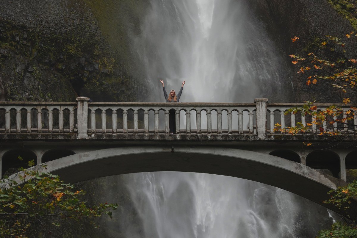 Multnomah Falls Oregon waterfall with mist rising and low fog clinging to forested cliffs