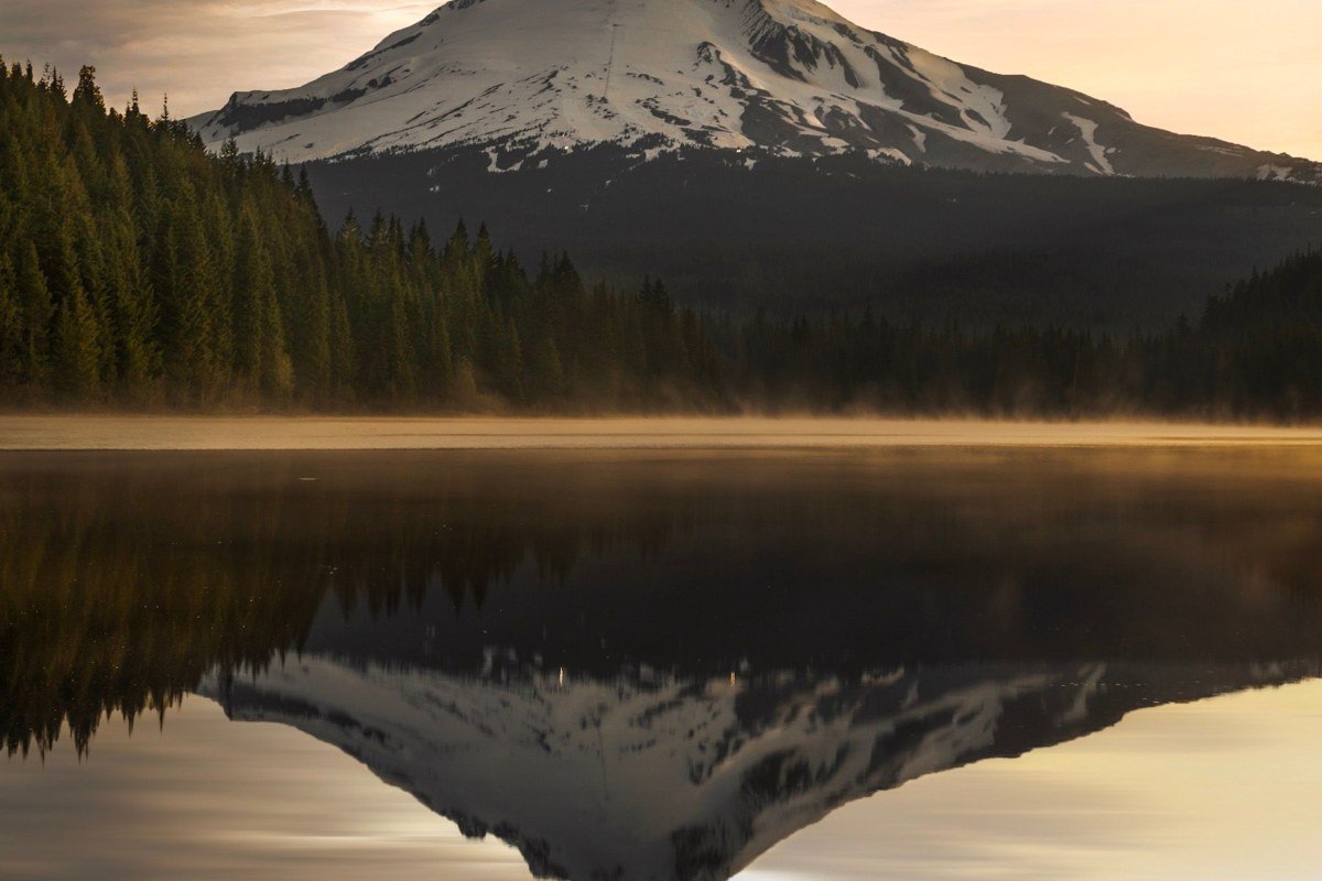 Trillium Lake Oregon still water with Mount Hood hidden behind fog and tree line reflection